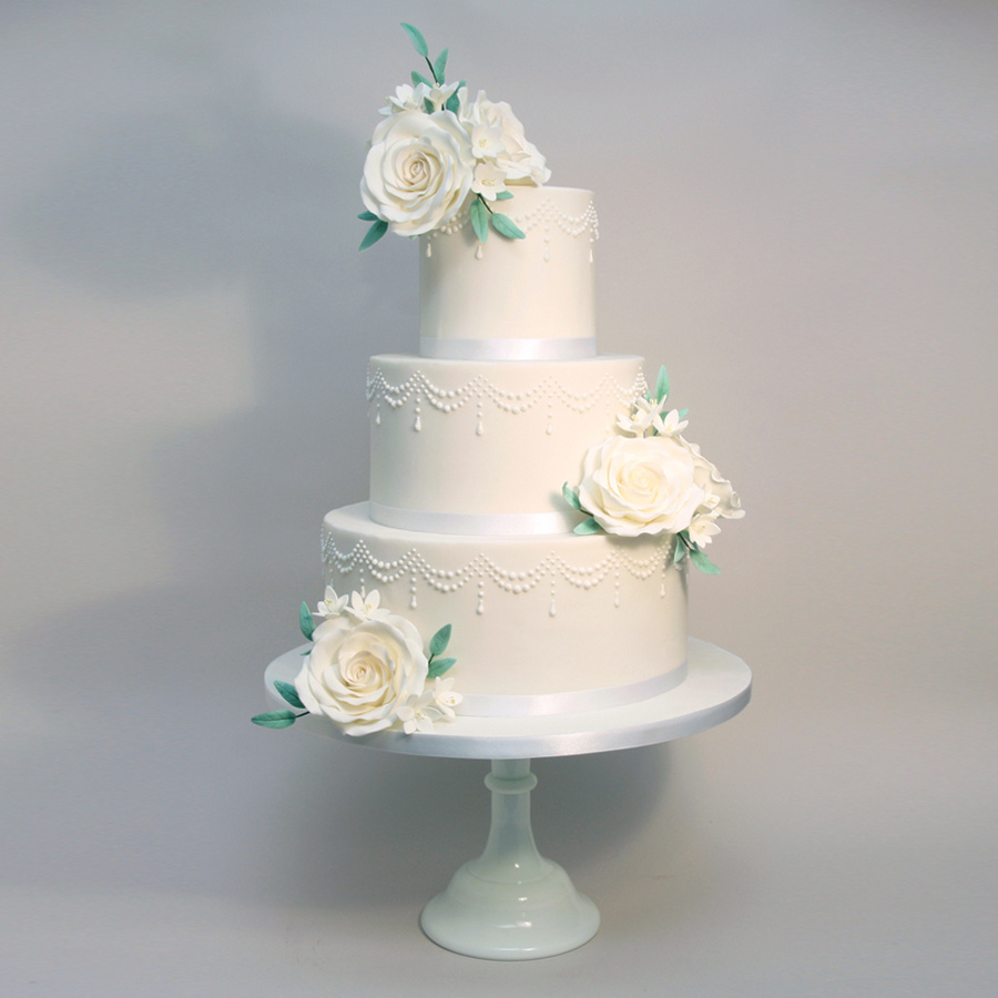 Piped drape cake with white roses