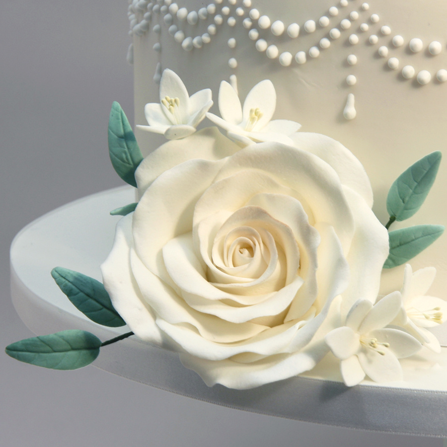 Piped drape cake with white roses